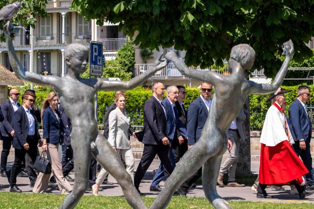 Switzerland's President Guy Parmelin (C-R), Poland's President Karol Nawrocki (C) and her wife Marta Nawrocka (C-L) walk toward the Belle Epoque - paddle steamboat "Savoie" of the "Compagnie Generale de Navigation sur le lac Leman" (commonly abbreviated "CGN") for a trip on Lake Geneva off Morges on May 28, 2026. Nawrocki is on two-day state visit in Switzerland. (Photo by MARTIAL TREZZINI / POOL / AFP)