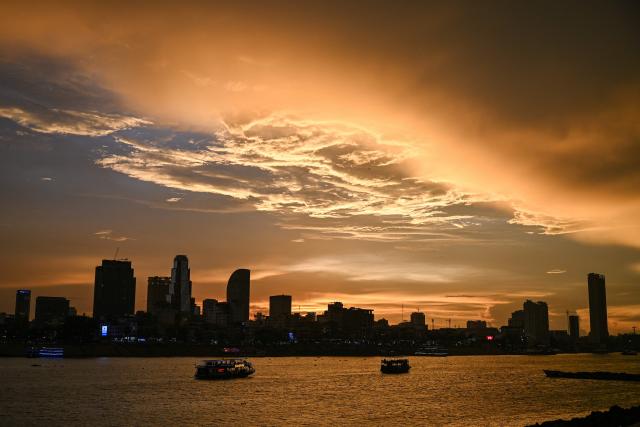 Tourist boats sail along the Tonle Sap river at sunset in Phnom Penh on May 28, 2026. (Photo by TANG CHHIN Sothy / AFP)