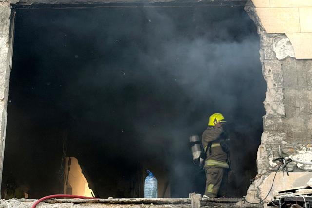 A rescue worker enters a smoke filled apartment block following an Israeli air strike in the Choueifat area, south of Beirut on the outskirts of the capitals southern suburbs, on May 28, 2026. A Lebanese military source told AFP that an Israeli strike hit an apartment south of Beirut on May 28, shortly after Israel's military said it launched a strike on the capital. The Israeli military said it launched an airstrike on the Lebanese capital Beirut after earlier strikes on the country's south killed at least 12 people, including two children, and wounded 21 others. (Photo by Ibrahim AMRO / AFP)