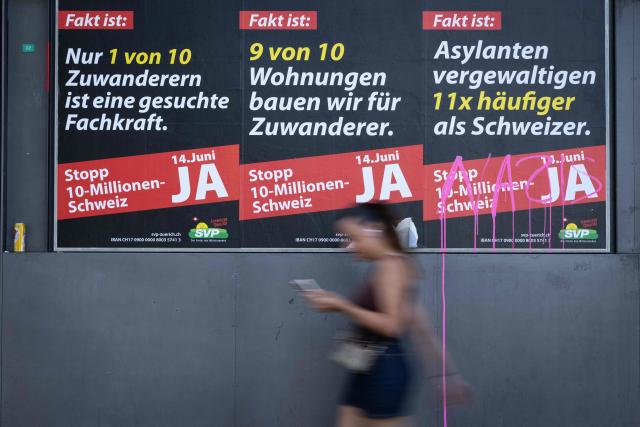 A woman passes by posters campaigning for the "yes" vote at next June 14's initiative launched by the hard-right Swiss People's Party (SVP) to cap the population at 10 million, an anti-immigration proposal that is fracturing public opinion in the wealthy Alpine nation, in Zurich on May 28, 2026. The panels slogans read in German (from L) : "The fact is: Only 1 in 10 immigrants is a skilled worker in demand", "The fact is: We build 9 out of 10 homes for immigrants" and "The fact is: Asylum seekers commit rape 11 times more often than Swiss nationals" (Photo by SEBASTIEN BOZON / AFP)