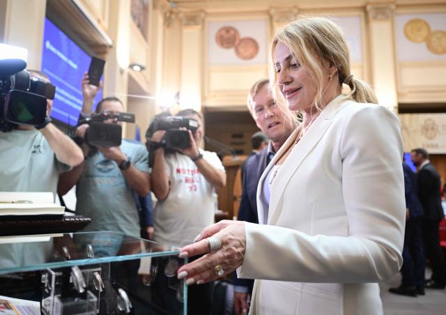 Romanian gymnastics legend Nadia Comaneci looks at he National Bank of Romania (BNR) in Bucharest on May 28, 2026. The central bank launched a special numismatic issue—comprising gold, silver, and copper-plated tombac coins—to mark the 50th anniversary of Com?neci achieving the first-ever perfect 10.0 score in Olympic history at the Montreal 1976 Games. The reverse of the coins depicts her iconic uneven bars routine and the historic "1.00" scoreboard display. (Photo by Daniel MIHAILESCU / AFP)