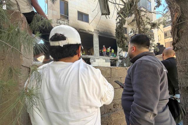 Residents look on as rescue workers search a damaged building following an Israeli air strike in the Choueifat area, south of Beirut on the outskirts of the capitals southern suburbs, on May 28, 2026. A Lebanese military source told AFP that an Israeli strike hit an apartment south of Beirut on May 28, shortly after Israel's military said it launched a strike on the capital. The Israeli military said it launched an airstrike on the Lebanese capital Beirut after earlier strikes on the country's south killed at least 12 people, including two children, and wounded 21 others. (Photo by Ibrahim AMRO / AFP)