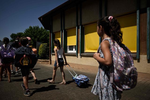 Pupils leave the Isle Verte primary school at midday which closes its doors on May 28 and 29 afternoon after a heatwave pushed temperatures up to 53°C at the beginning of the week, in Soustons, south-western France, on May 28, 2026. Western Europe faced another day of record-breaking temperatures as a heatwave pushed the mercury well above normal levels for May. A so-called "heat dome" of warm air from northern Africa trapped under a high-pressure system over western Europe is behind the sort of heat not usually seen until high summer. (Photo by Philippe LOPEZ / AFP)