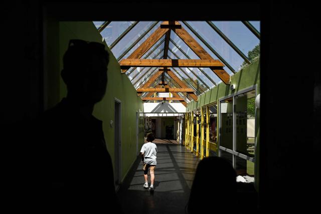 A child walks along the glass-roofed corridor of the Isle Verte primary school which closes its doors on May 28 and 29 afternoon after a heatwave pushed temperatures up to 53°C at the beginning of the week, in Soustons, south-western France, on May 28, 2026. Western Europe faced another day of record-breaking temperatures as a heatwave pushed the mercury well above normal levels for May. A so-called "heat dome" of warm air from northern Africa trapped under a high-pressure system over western Europe is behind the sort of heat not usually seen until high summer. (Photo by Philippe LOPEZ / AFP)