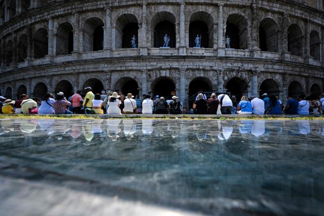 People sit in the shade of the Colosseum during an early-season heatwave in Rome on May 28, 2026.  (Photo by Tiziana FABI / AFP)