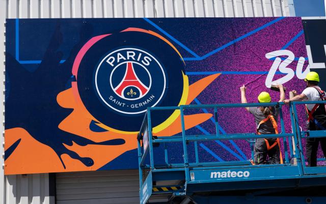 Workers put up a giant poster featureing Paris Saint-Germain (PSG) at the Puskas Arena on May 28, 2026 ahead of the UEFA Champions League in Budapest on May 28, 2026. The stadium, named after Hungary's most famous footballer Ferenc Puskas, will host the Champions League final between Paris Saint-Germain (PSG) and Arsenal on May 30, 2026. (Photo by Attila KISBENEDEK / AFP)