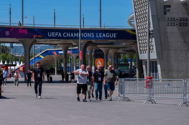 Technicians and volunteers walk around the Puskas Arena is pictured on May 28, 2026 ahead of the UEFA Champions League in Budapest on May 28, 2026. The stadium, named after Hungary's most famous footballer Ferenc Puskas, will host the Champions League final between Paris Saint-Germain (PSG) and Arsenal on May 30, 2026. (Photo by Attila KISBENEDEK / AFP)