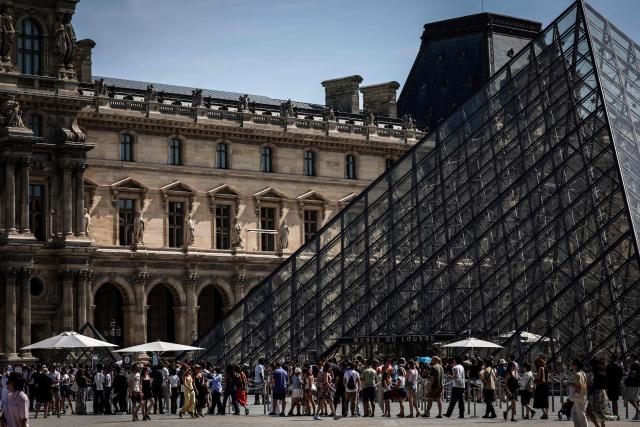 Tourists queue at the Louvre Museum in Paris on May 28, 2026, as a heatwave hits France. French weather service Météo-France placed the capital under yellow alert amid an exceptionally early heatwave, with temperatures forecast to reach 35C across the region. (Photo by STEPHANE DE SAKUTIN / AFP)