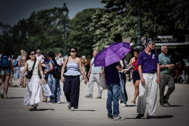 Pedestrians walk in Paris on May 28, 2026, as a heatwave hits France. French weather service Météo-France placed the capital under yellow alert amid an exceptionally early heatwave, with temperatures forecast to reach 35C across the region. (Photo by STEPHANE DE SAKUTIN / AFP)