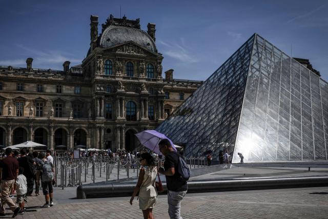 Tourists queue at the Louvre Museum in Paris on May 28, 2026, as a heatwave hits France. French weather service Météo-France placed the capital under yellow alert amid an exceptionally early heatwave, with temperatures forecast to reach 35C across the region. (Photo by STEPHANE DE SAKUTIN / AFP)