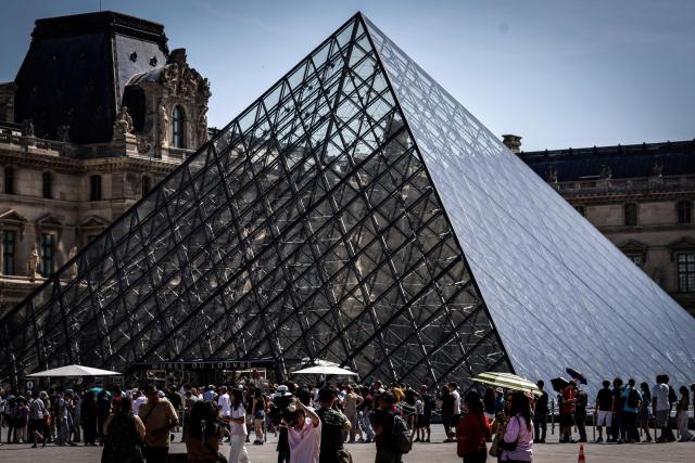 Tourists queue at the Louvre Museum in Paris on May 28, 2026, as a heatwave hits France. French weather service Météo-France placed the capital under yellow alert amid an exceptionally early heatwave, with temperatures forecast to reach 35C across the region. (Photo by STEPHANE DE SAKUTIN / AFP)