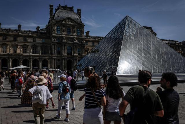 Tourists queue at the Louvre Museum in Paris on May 28, 2026, as a heatwave hits France. French weather service Météo-France placed the capital under yellow alert amid an exceptionally early heatwave, with temperatures forecast to reach 35C across the region. (Photo by STEPHANE DE SAKUTIN / AFP)