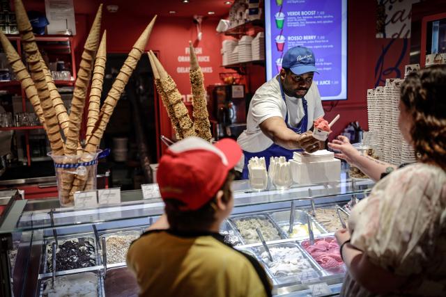 An ice cream vendor sells ice cream to customers in Paris on May 28, 2026, as a heatwave hits France. French weather service Météo-France placed the capital under yellow alert amid an exceptionally early heatwave, with temperatures forecast to reach 35C across the region. (Photo by STEPHANE DE SAKUTIN / AFP)