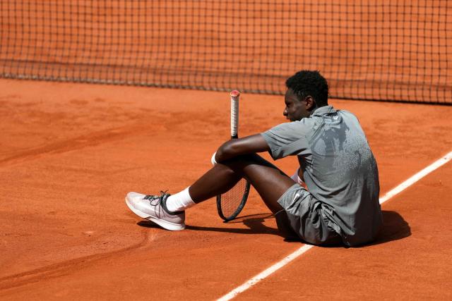 France's Moise Kouame sits on the court after falling during his men's singles match against Paraguay's Adolfo Daniel Vallejo on day 5 of the French Open tennis tournament on Court Suzanne-Lenglen at the Roland-Garros Complex in Paris on May 28, 2026. (Photo by Dimitar DILKOFF / AFP)