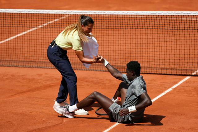 Brazilian chair umpire Ana Carvalho helps France's Moise Kouame to stand up after he fell on the court while playing against Paraguay's Adolfo Daniel Vallejo during their men's singles match on day 5 of the French Open tennis tournament on Court Suzanne-Lenglen at the Roland-Garros Complex in Paris on May 28, 2026. (Photo by Dimitar DILKOFF / AFP)
