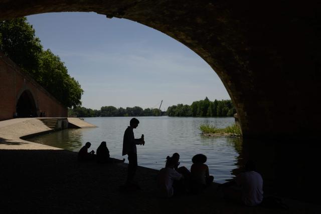 People shelter from the sun under a bridge on the banks of the River Garonne in Toulouse, southwestern France, on May 28, 2026 as a heatwave hits France. Western Europe faced another day of record-breaking temperatures as a heatwave pushed the mercury well above normal levels for May. A so-called "heat dome" of warm air from northern Africa trapped under a high-pressure system over western Europe is behind the sort of heat not usually seen until high summer. (Photo by Ed JONES / AFP)
