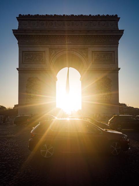 The sun sets behind the Arc de Triomphe monument in Paris as a record-breaking early heatwave scorches a swathe of western Europe on May 27, 2026. The UK and France have reported their hottest ever May days this week as a "heat dome" brought sizzling temperatures more typical of midsummer to western Europe. (Photo by Laurent EMMANUEL / AFP)