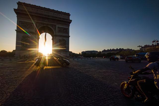 The sun sets behind the Arc de Triomphe monument in Paris as a record-breaking early heatwave scorches a swathe of western Europe on May 27, 2026. The UK and France have reported their hottest ever May days this week as a "heat dome" brought sizzling temperatures more typical of midsummer to western Europe. (Photo by Laurent EMMANUEL / AFP)