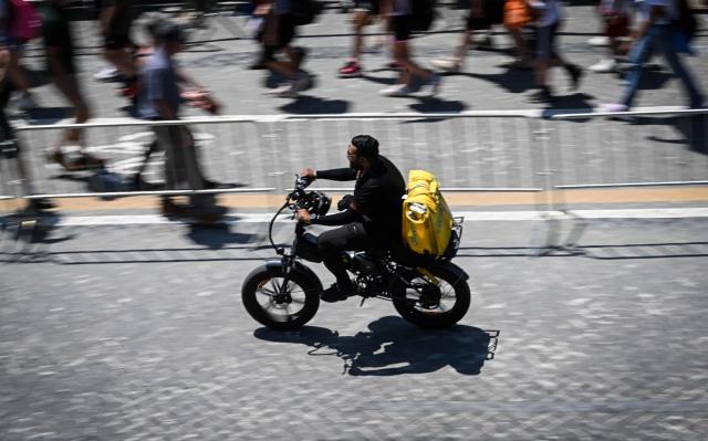 A food delivery firm Glovo's rider cycles along the Imperial Forum in Rome on May 28, 2026. (Photo by Tiziana FABI / AFP)