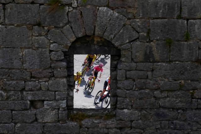 Team Visma Lease a Bike Danish rider Jonas Vingegaard is seen through a stone wall during the 18th stage of the Giro d'Italia 2026 - Tour of Italy cycling race between Fai della Paganella and Pieve di Soligo, Italy, on May 28, 2026. (Photo by Luca Bettini / AFP)
