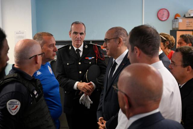 France's Interior Minister Laurent Nunez (C-R),  Interdepartmental Director of the National Police, Frédéric Pizzini (C) and Prefect of the Alpes-Maritimes department Laurent Hottiaux (R) meet with local police officers of the National Police force during a visit to the Les Moulins neighbourhood in Nice, south-eastern France on May 28, 2026. Two men and a woman suspected of being involved in a shooting that left two people dead and six injured in Nice on May 11 in the Les Moulins district of Nice have been charged and remanded in custody, in a new case illustrating the turf wars associated with drug-related gang activity. (Photo by Frederic DIDES / AFP)