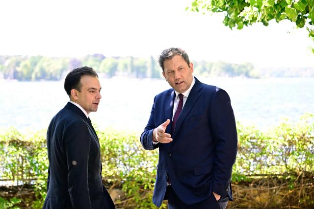 Germany's Finance Minister Lars Klingbeil (R) and Poland's Finance Minister Andrzej Domanski chat by the water prior to a meeting at the Recreation Center of the German central bank (Deutsche Bundesbank) at Wannsee lake in Berlin on May 28, 2026. (Photo by Tobias SCHWARZ / AFP)