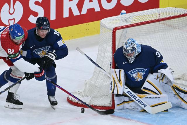 Czech Republic's forward #61 Martin Kaut (L) and Finland's defender #10 Henri Jokiharjuvie (C) for the puck past Finland's goalkeeper Justus Annunen during the IIHF Ice Hockey Men's World Championship quarter-final match between Finland and Czech Republic at the Swiss Life Arena in Zurich, Switzerland on May 28, 2026. (Photo by SEBASTIEN BOZON / AFP)