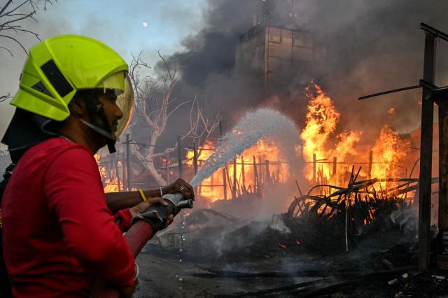 A firefighter tries to douse a fire that broke out at a bamboo market in Amritsar on May 28, 2026. (Photo by Narinder NANU / AFP)