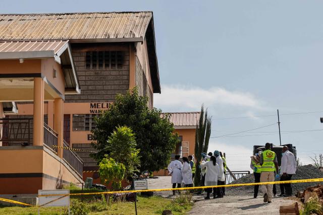 Kenyan police detectives and forensic experts stand next a building at Utumishi Girls Academy where a deadly fire took place in Gilgil, north of the capital Nairobi on May 28, 2026. A fire in a girls' dormitory in Kenya on May 28 killed 16 children and hospitalised 79 in the latest deadly blaze to hit a school in the east African country. The fire broke out shortly before 1:00 am local time at Utumishi Girls Academy in Nakuru County, around 120 kilometres (75 miles) north of the capital Nairobi, officials said. (Photo by SIMON MAINA / AFP)