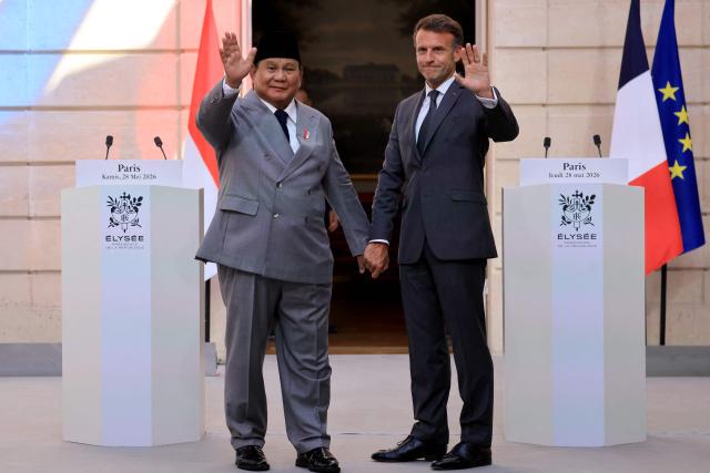 France's President Emmanuel Macron (R) and Indonesia's President Prabowo Subianto wave during a joint press statement at The Elysee Presidential Palace in Paris on May 28, 2026. (Photo by Ludovic MARIN / POOL / AFP)