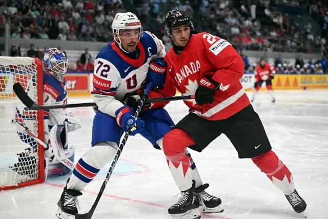USA's defender #72 Justin Faulk (L) and Canada’s forward #24 Dylan Cozens vie for the puck during the IIHF Ice Hockey Men's World Championship quarter-final match between Canada and USA in Fribourg, Switzerland on May 28, 2026. (Photo by Fabrice COFFRINI / AFP)