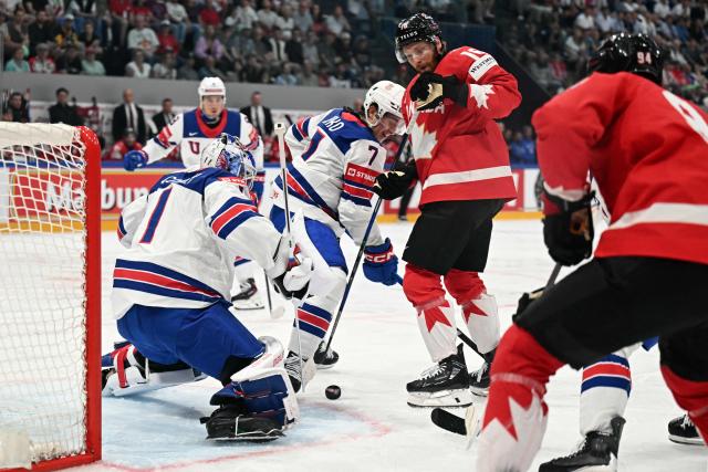 USA's goalkeeper #1 Devin Cooley (L), USA's defender #7 Ryan Ufko (C) and Canada’s forward #16 Connor Brown (2R) vie for the puck during the IIHF Ice Hockey Men's World Championship quarter-final match between Canada and USA in Fribourg, Switzerland on May 28, 2026. (Photo by Fabrice COFFRINI / AFP)