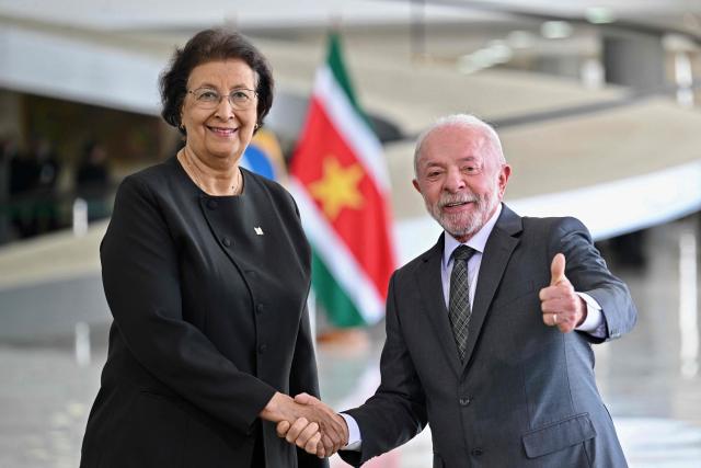 Suriname’s President Jennifer Geerlings-Simons (L) and Brazil’s President Luiz Inacio Lula da Silva shake hands during a meeting at Planalto Palace in Brasilia, on May 28, 2025. (Photo by Evaristo Sa / AFP)
