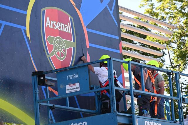 Workers put up a giant UEFA Champions League final poster featuring the Arsenal emblem at the Puskas Arena on May 28, 2026 ahead of the UEFA Champions League in Budapest on May 28, 2026. The stadium, named after Hungary's most famous footballer Ferenc Puskas, will host the Champions League final between Paris Saint-Germain (PSG) and Arsenal on May 30, 2026. (Photo by Attila KISBENEDEK / AFP)