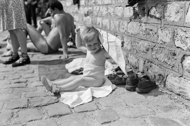 (FILES) A baby protects himself from the sun on the banks of the Seine river on June 5, 1950, during a heat wave in Paris. (Photo by AFP)