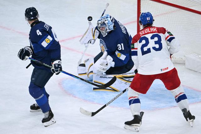 Finland's goalkeeper #31 Justus Annunen (C) dives for the puck past Czech Republic's forward #23 Lukas Sedlak and Finland's defender #41 Ville Heinola during the IIHF Ice Hockey Men's World Championship quarter-final match between Finland and Czech Republic at the Swiss Life Arena in Zurich, Switzerland on May 28, 2026. (Photo by SEBASTIEN BOZON / AFP)