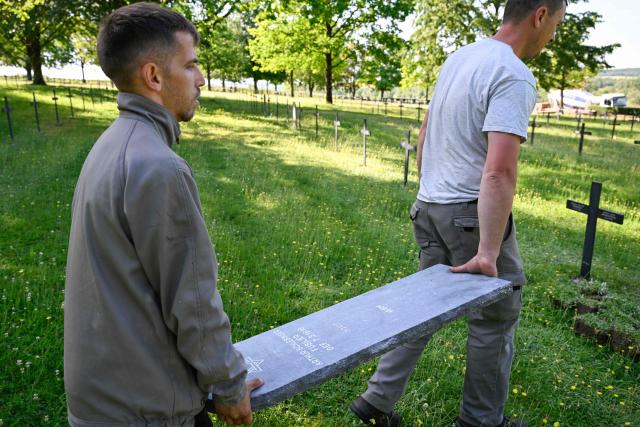 Members of "Service Entretien Sépultures Militaires Allemandes (SESMA)"  of Volksbund Deutsche Kriegsgräberfürsorge (German War Graves Commission) carrie a gravestone of a Jewish soldier from the First World War at the Consenvoye German WWI cemetery (Verdun battlefield) to better reflect his religion, in Consenvoye, northeastern France, on May 18, 2026. An unveiling ceremony will take place on June 3 , 2026. (Photo by Jean-Christophe Verhaegen / AFP)