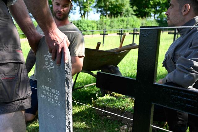 Members of "Service Entretien Sépultures Militaires Allemandes (SESMA)"  of Volksbund Deutsche Kriegsgräberfürsorge (German War Graves Commission) replace gravestones of a Jewish soldiers from the First World War at the Consenvoye German WWI cemetery (Verdun battlefield) to better reflect their religion, in Consenvoye, northeastern France, on May 18, 2026. An unveiling ceremony will take place on June 3 , 2026. (Photo by Jean-Christophe Verhaegen / AFP)