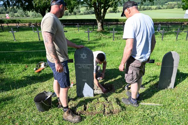 Members of "Service Entretien Sépultures Militaires Allemandes (SESMA)" of Volksbund Deutsche Kriegsgräberfürsorge (German War Graves Commission) replace gravestones of Jewish soldiers from the First World War at the Consenvoye German WWI cemetery (Verdun battlefield) to better reflect their religion, in Consenvoye, northeastern France, on May 18, 2026. An unveiling ceremony will take place on June 3 , 2026. (Photo by Jean-Christophe Verhaegen / AFP)