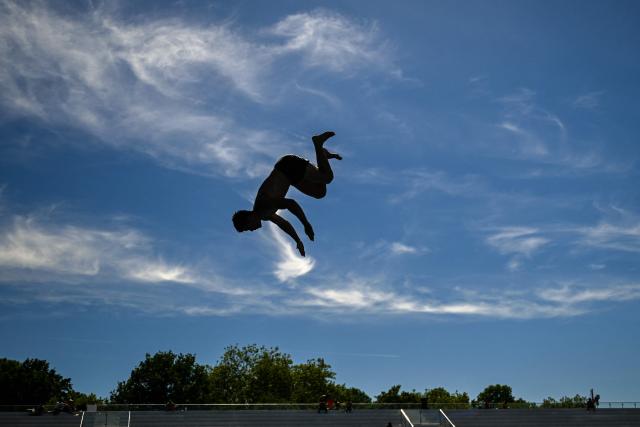 A man jumps from the 10-meter tower in the Grugabad in Essen, western Germany, on May 28, 2026, as temperatures in Germany remain unsuaually high for the season.. (Photo by Ina FASSBENDER / AFP)
