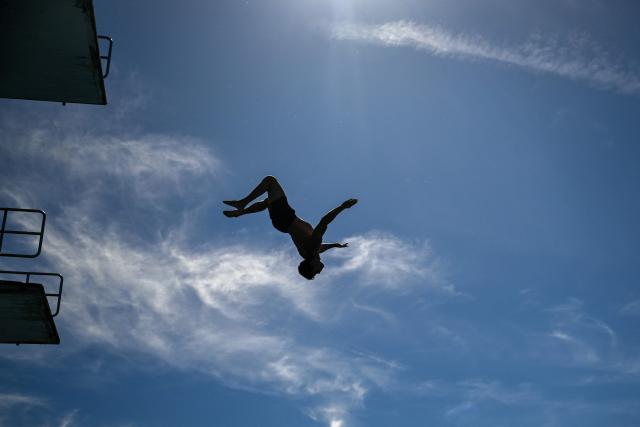 A man jumps from the 10-meter tower in the Grugabad in Essen, western Germany, on May 28, 2026, as temperatures in Germany remain unsuaually high for the season.. (Photo by Ina FASSBENDER / AFP)
