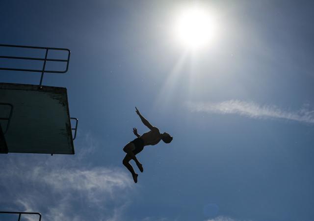 A man jumps from the 10-meter tower in the Grugabad in Essen, western Germany, on May 28, 2026, as temperatures in Germany remain unsuaually high for the season.. (Photo by Ina FASSBENDER / AFP)