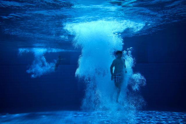 A young man is seen under water after he jumped from the 10-meter tower in the Grugabad in Essen, western Germany, on May 28, 2026, as temperatures in Germany remain unsuaually high for the season.. (Photo by Ina FASSBENDER / AFP)