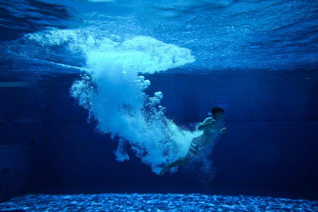 A young man is seen under water after he jumped from the 10-meter tower in the Grugabad in Essen, western Germany, on May 28, 2026, as temperatures in Germany remain unsuaually high for the season.. (Photo by Ina FASSBENDER / AFP)