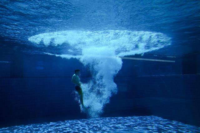 A young man is seen under water after he jumped from the 10-meter tower in the Grugabad in Essen, western Germany, on May 28, 2026, as temperatures in Germany remain unsuaually high for the season.. (Photo by Ina FASSBENDER / AFP)