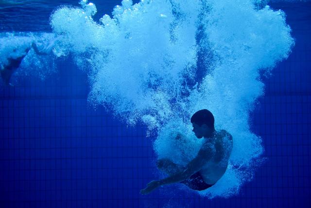 A young man is seen under water after he jumped from the 10-meter tower in the Grugabad in Essen, western Germany, on May 28, 2026, as temperatures in Germany remain unsuaually high for the season.. (Photo by Ina FASSBENDER / AFP)