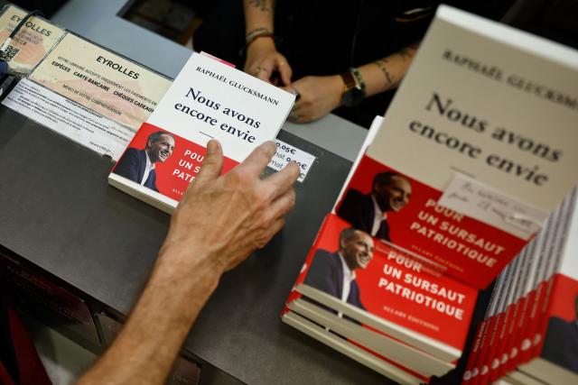 This photograph taken on May 28, 2026 shows a copy of the newly released book titled "Nous Avons Encore Envie" (We still want to) by Place publique's centre-left party leader and France's MEP Raphael Glucksmann being purchased ahead of a book-signing session at the Eyrolles publisher bookshop in Paris. (Photo by SIMON WOHLFAHRT / AFP)