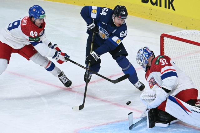 Czech Republic's goalkeeper #32 Josef Korenar dives for the puck past Finland's forward #64 Mikael Granlund during the IIHF Ice Hockey Men's World Championship quarter-final match between Finland and Czech Republic at the Swiss Life Arena in Zurich, Switzerland on May 28, 2026. (Photo by SEBASTIEN BOZON / AFP)
