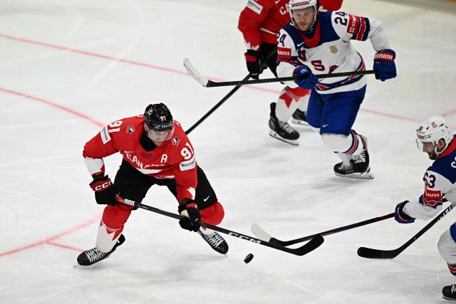 Canada’s forward #91 John Tavares (L) vies for the puck with USA's forward #63 Max Sasson (R) and USA's forward #24 Mathieu Olivier (top C) during the IIHF Ice Hockey Men's World Championship quarter-final match between Canada and USA in Fribourg, Switzerland on May 28, 2026. (Photo by Fabrice COFFRINI / AFP)