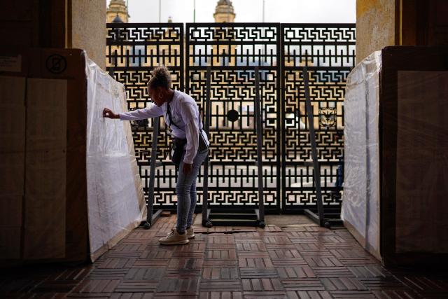 An employee of the national registry searches a polling station on a chart in Bogota on May 28, 2026. Colombia will hold presidential elections on May 31, 2026. (Photo by Sergio ANGEL / AFP)